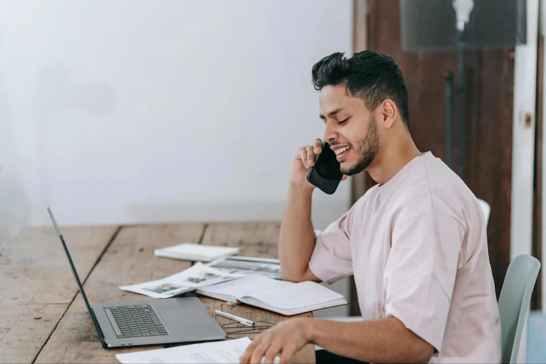 Male looking at his notes while speaking on a call